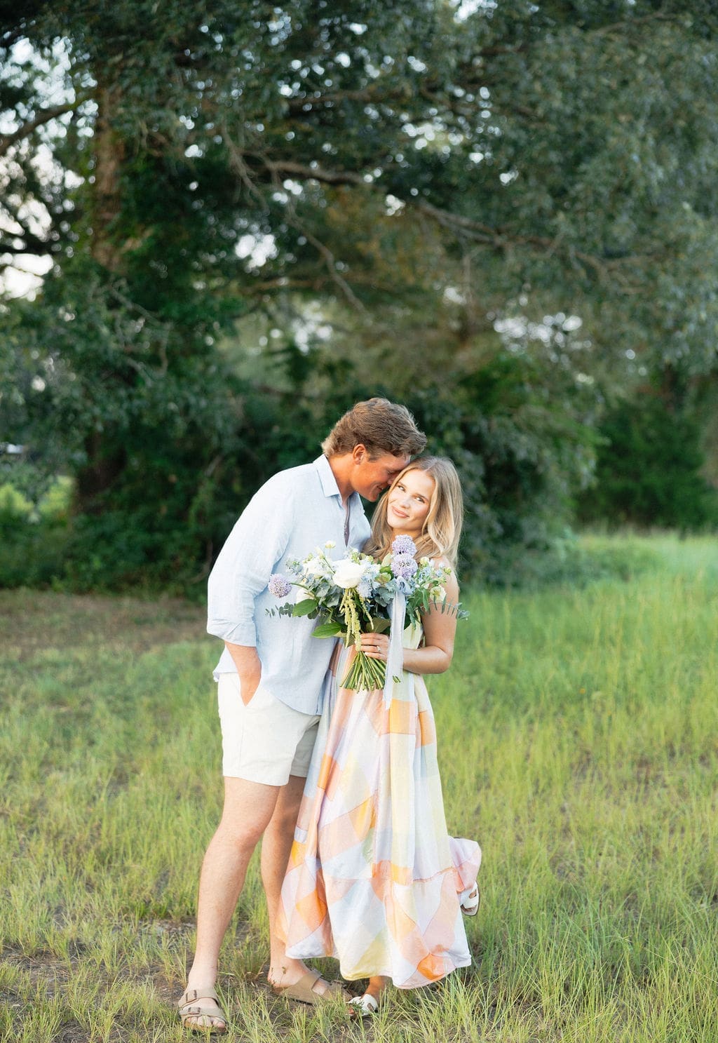 Husband leaning into his wife with a smile during their gender reveal photoshoot.