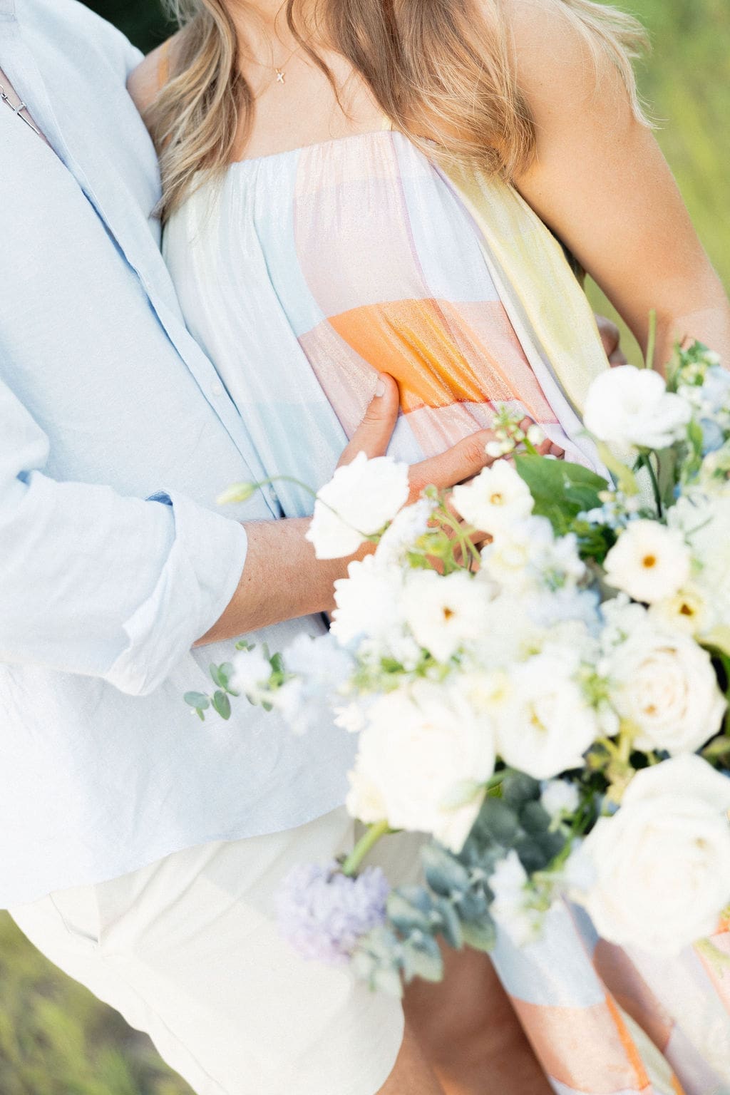 Gender reveal photo ideas: A closeup photo of a couple + floral bouquet that they used to reveal their baby's gender.