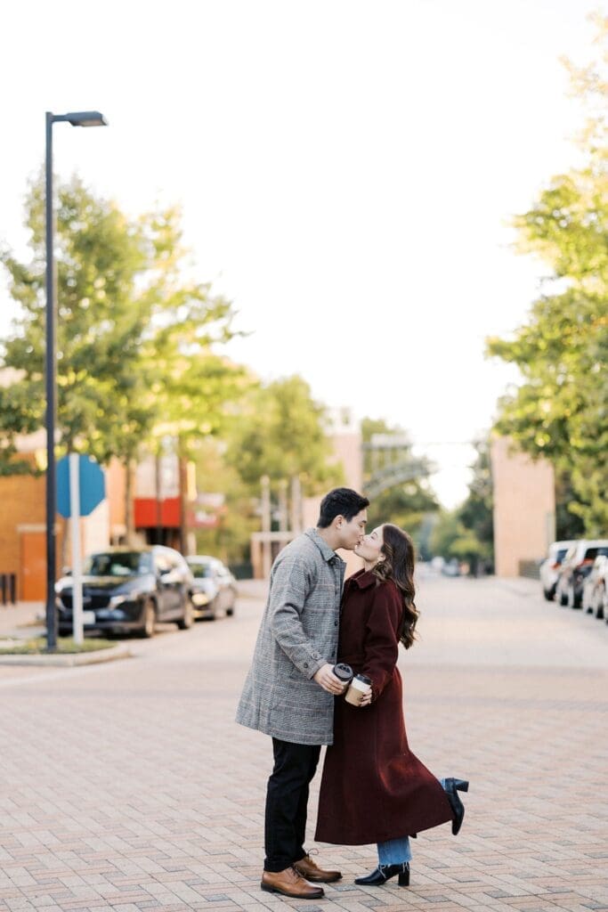 Romantic Engagement Photo Ideas: A couple kissing in the street during their morning engagement shoot at The Woodlands of Texas