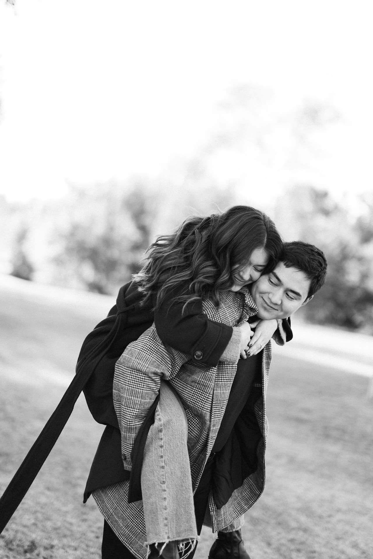 Romantic Engagement Photo Ideas: A couple playing a round in a field with the girl getting a piggy back ride from her fiance.