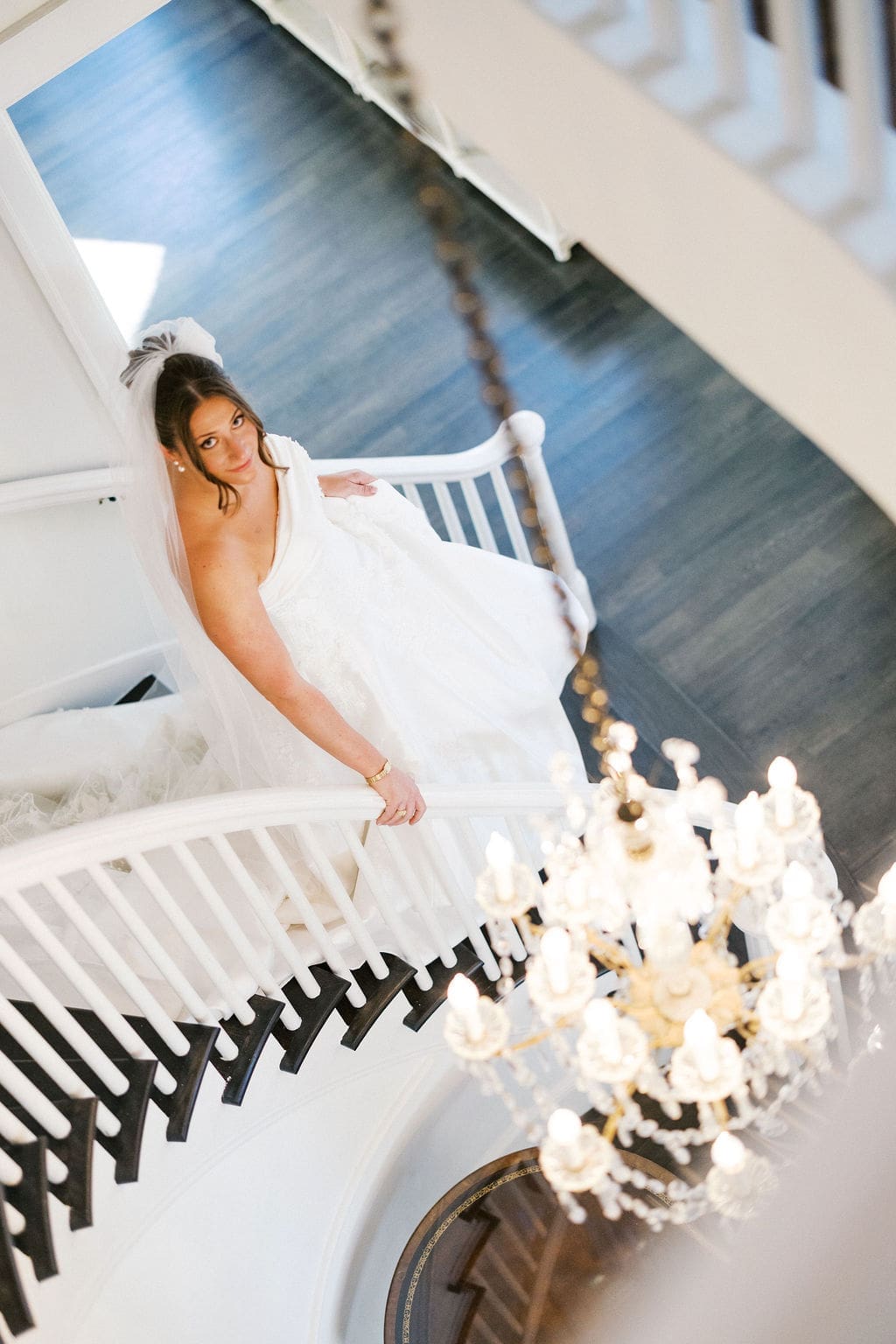 An elegant bridal photo with the bride walking down the staircase.