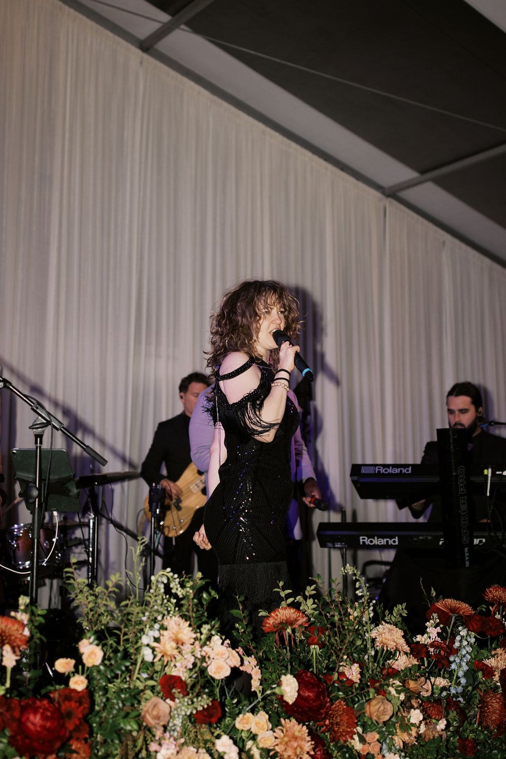Live band performing on stage with vibrant lighting during a high-energy Mansion Wedding reception.
