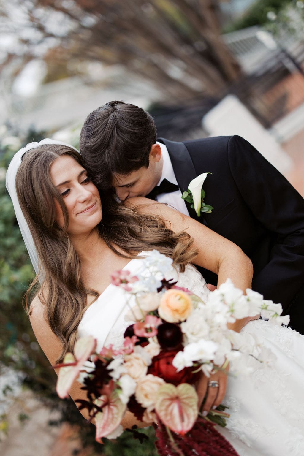 Bride and groom sharing an intimate portrait with a colorful bouquet during a romantic Mansion Wedding portrait session.
