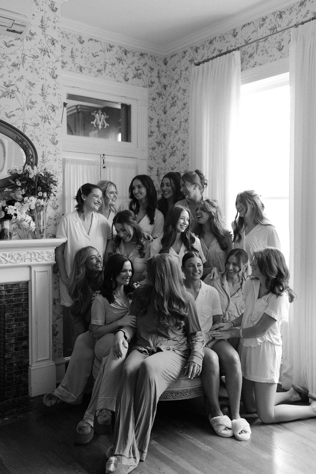Bridesmaids gathered together in matching getting-ready outfits inside a charming historic room during a joyful Mansion Wedding morning.