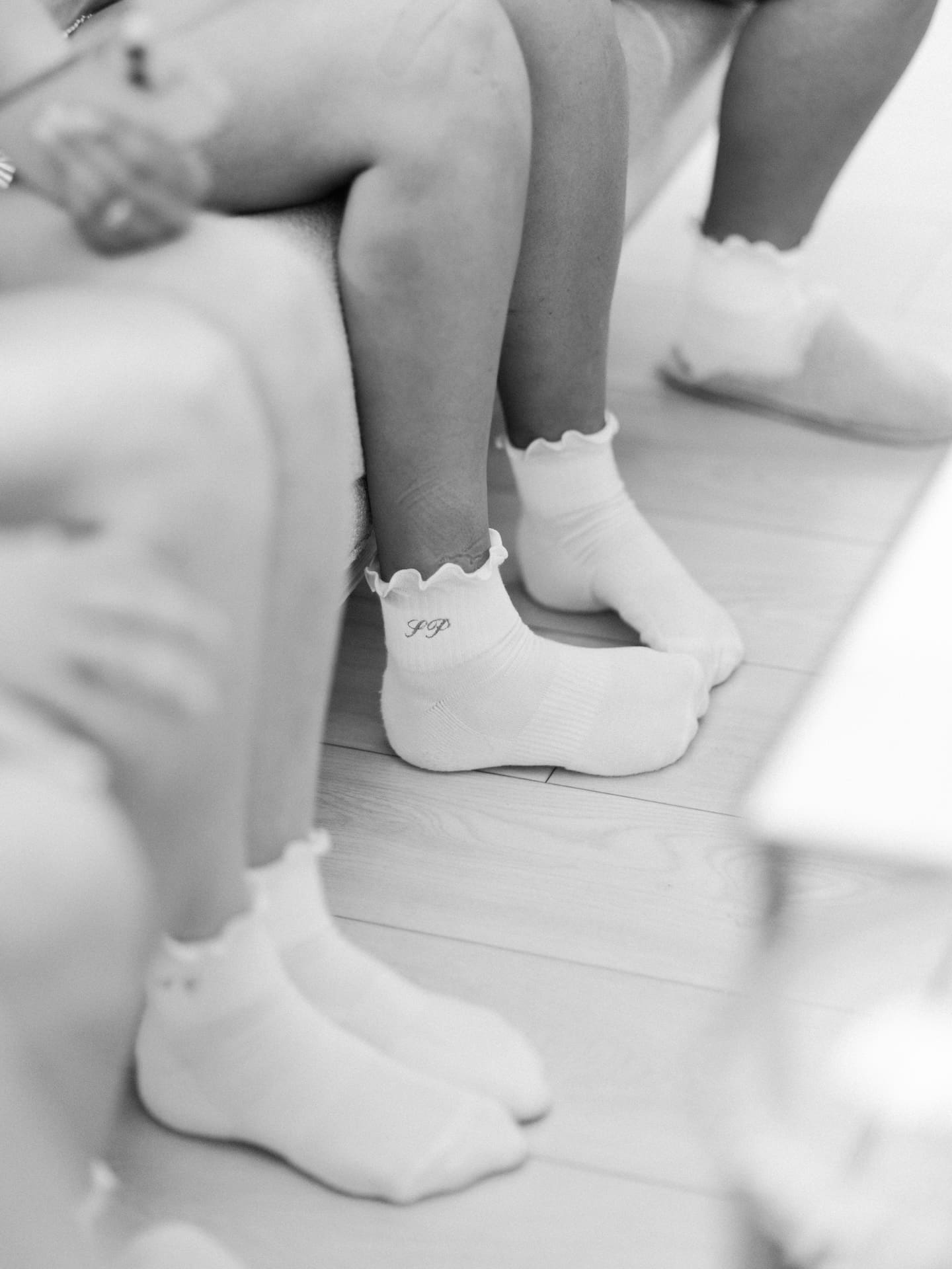 A sweet black and white detail shot of the bridesmaids' white frilly monogrammed socks during the getting-ready morning.