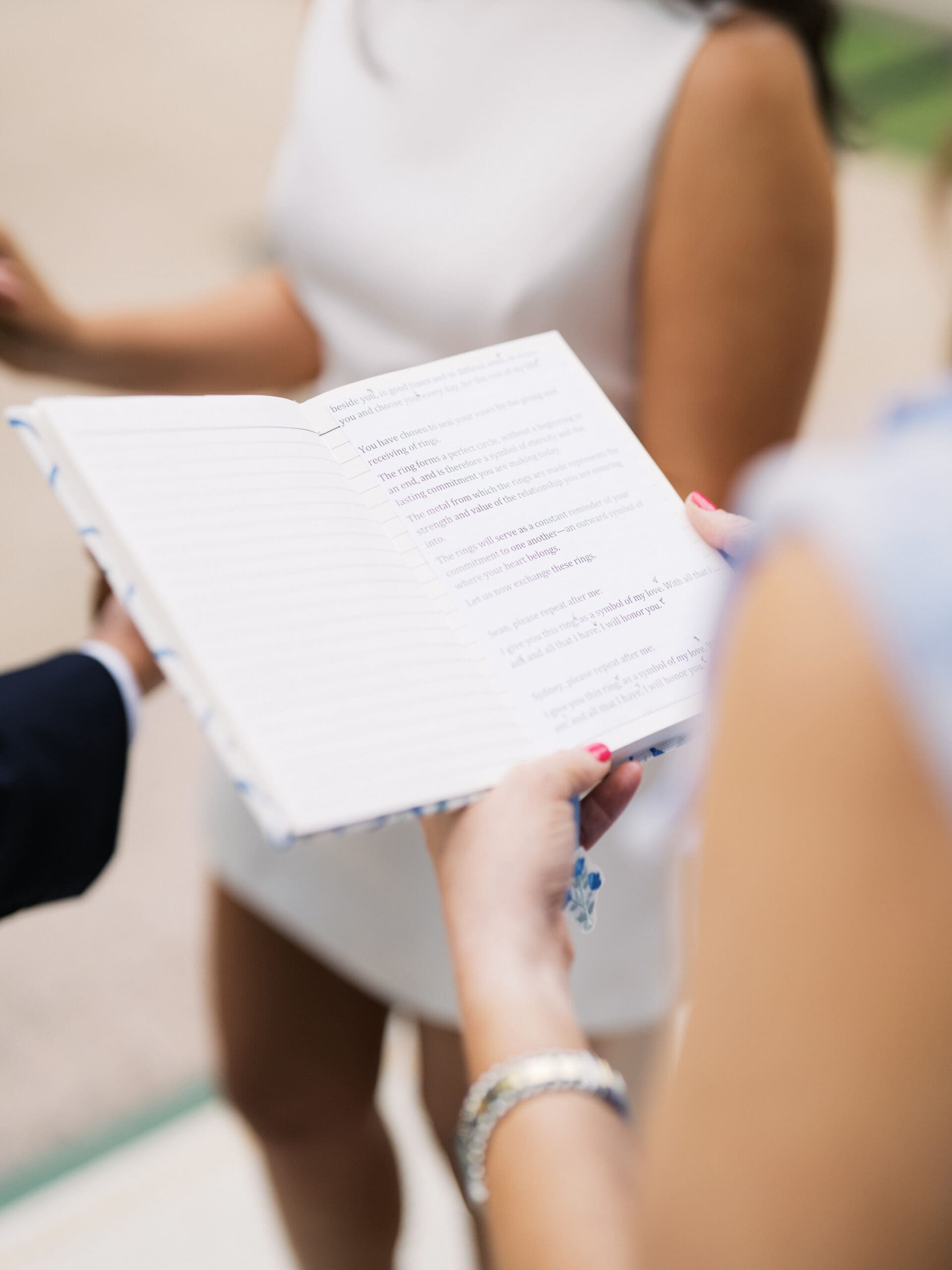 Overhead close-up of a wedding officiant holding an open ceremony book
