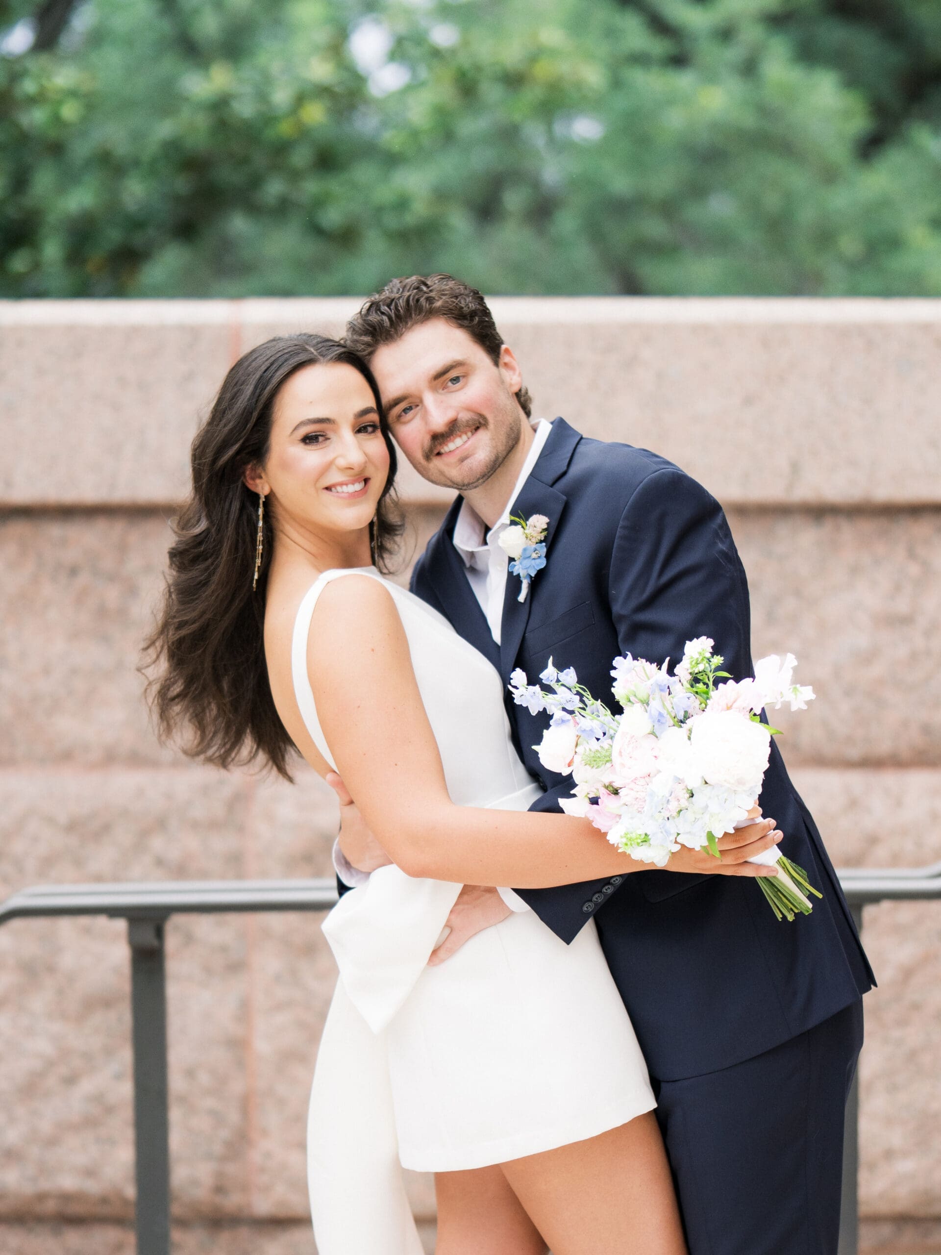 Smiling bride and groom embracing outside the courthouse during their courthouse wedding in Houston
