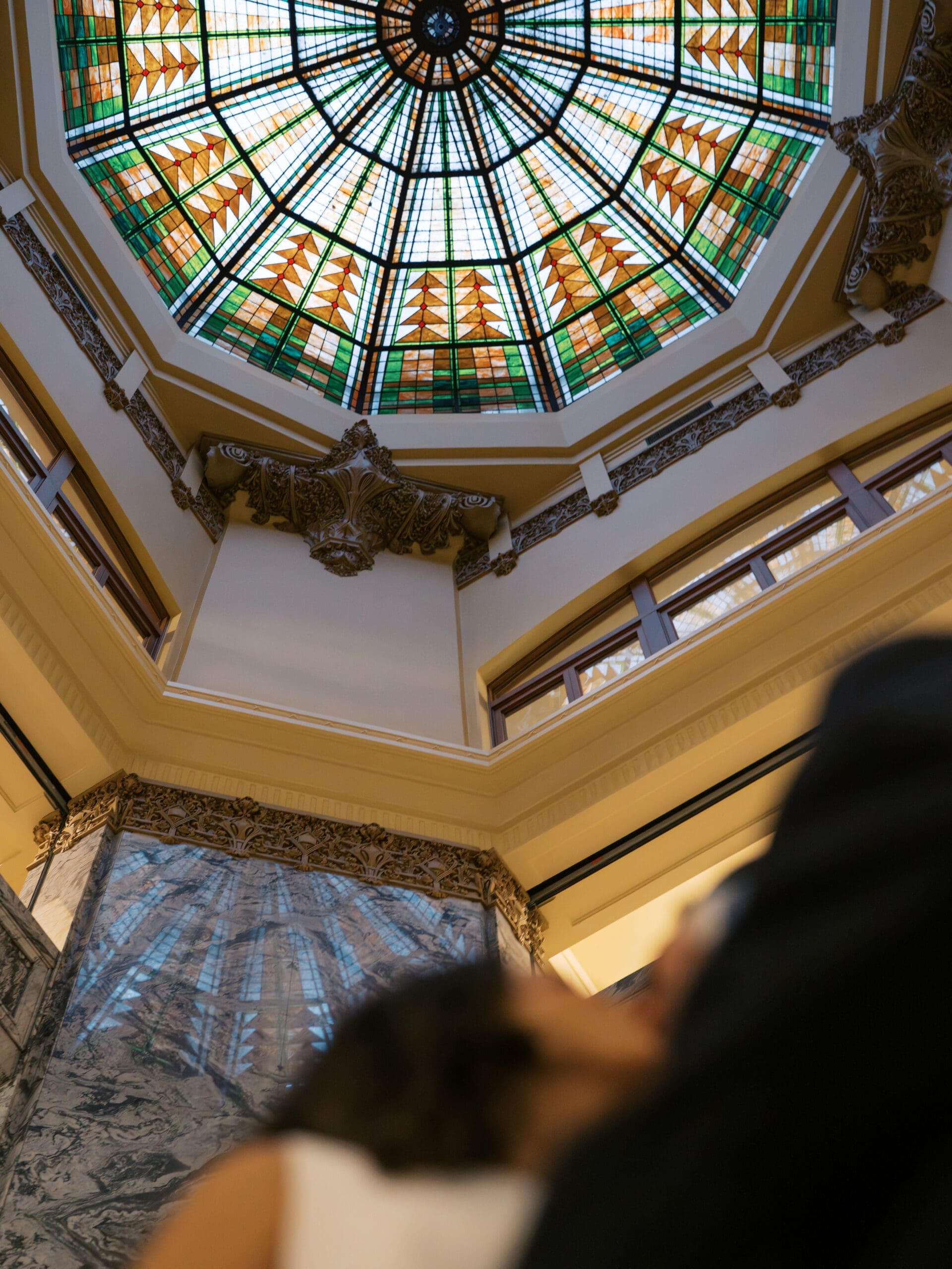 The bride and groom looking up into the Rotunda at the courthouse in Houston.