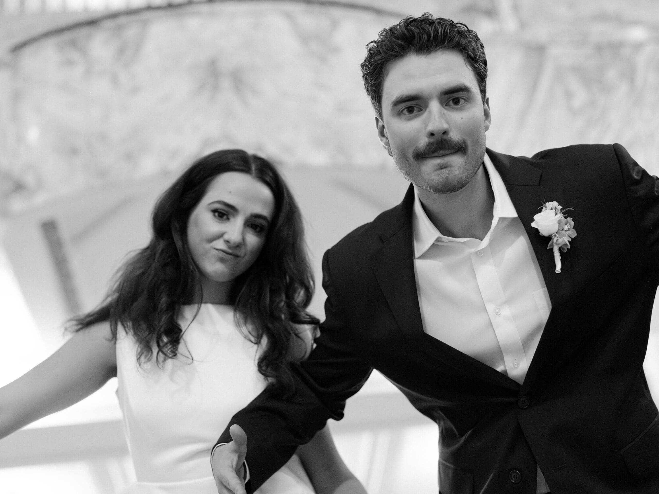 Black and white close-up portrait of a bride and groom making a playful face at the camera during their courthouse wedding in Houston
