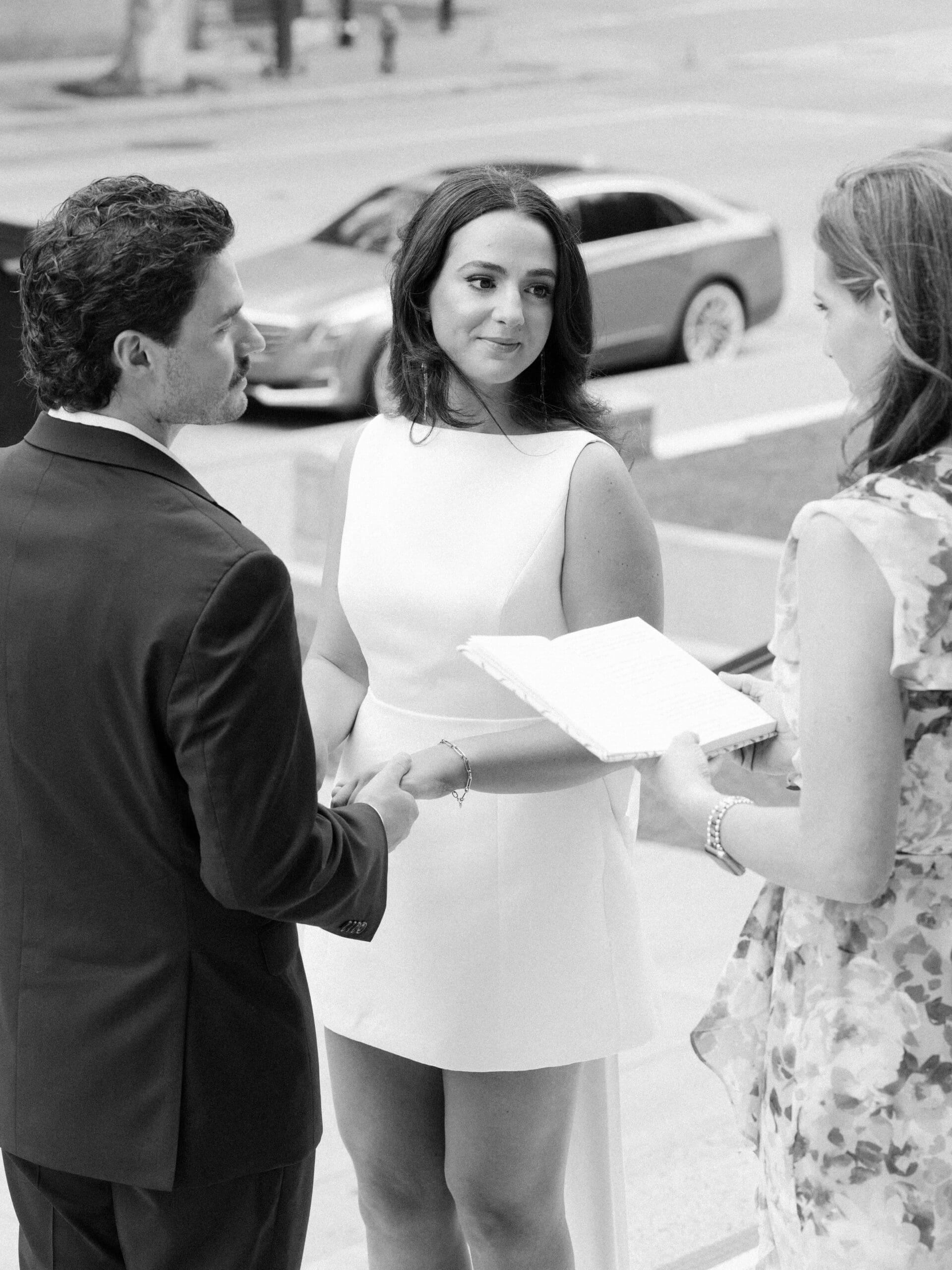 Bride and groom holding hands with their officiant during their courthouse wedding in Houston ceremony
