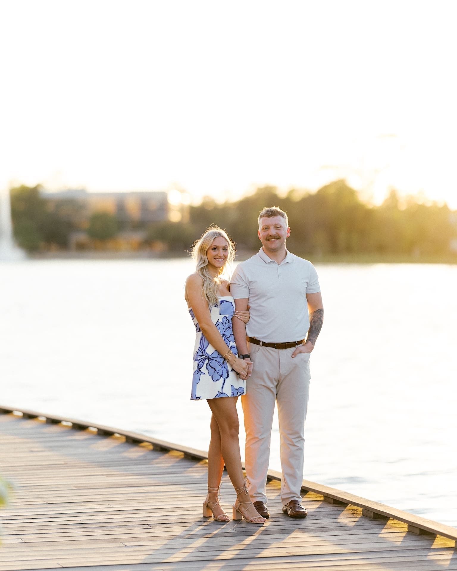 Man and woman smiling together on a dock at sunset, a perfect example of how to plan a proposal with golden hour timing in Houston
