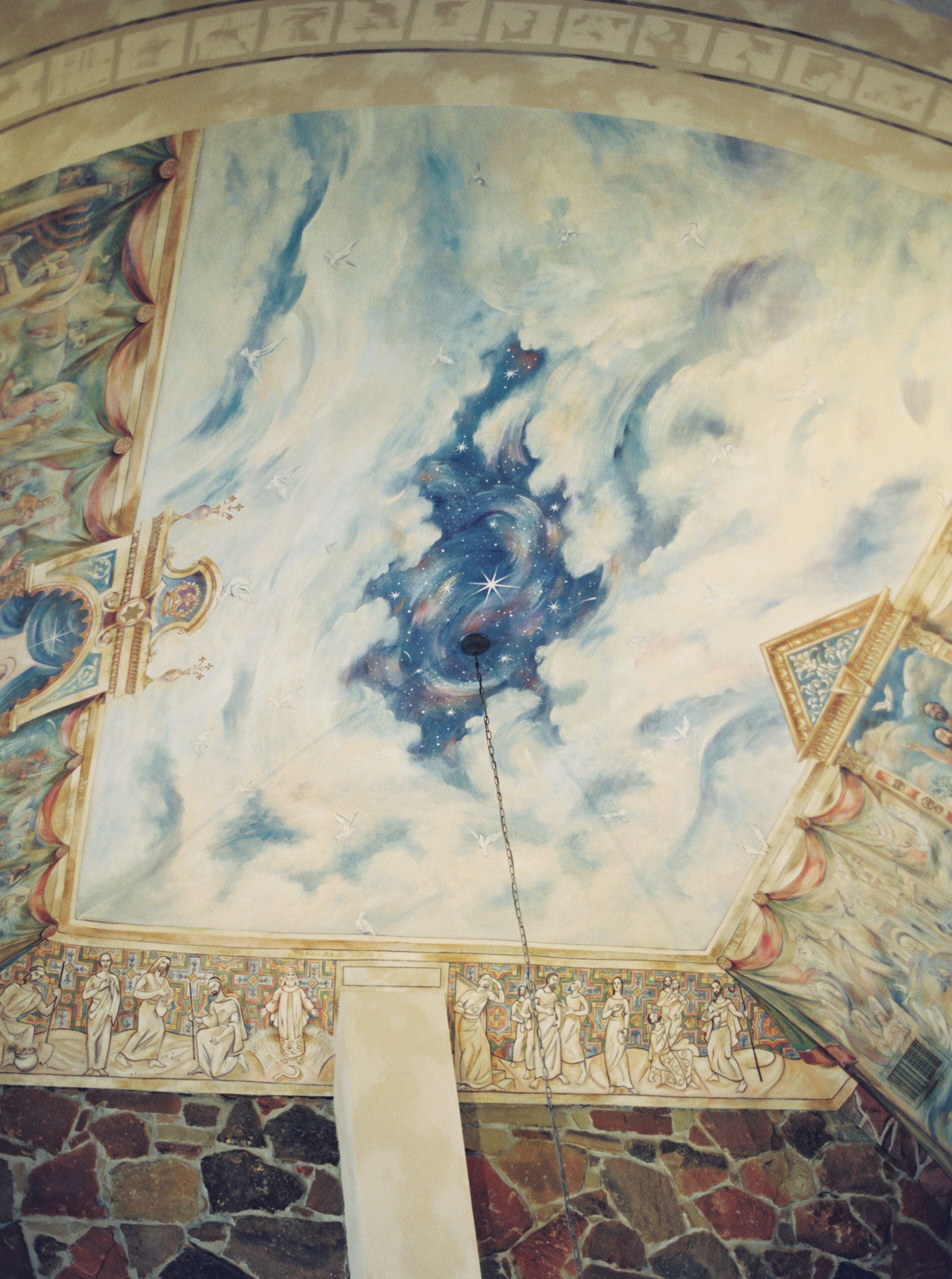 Stunning hand-painted ceiling mural inside The Lanier Theological Library chapel, featuring swirling clouds, stars, and celestial imagery surrounded by ornate decorative borders.
