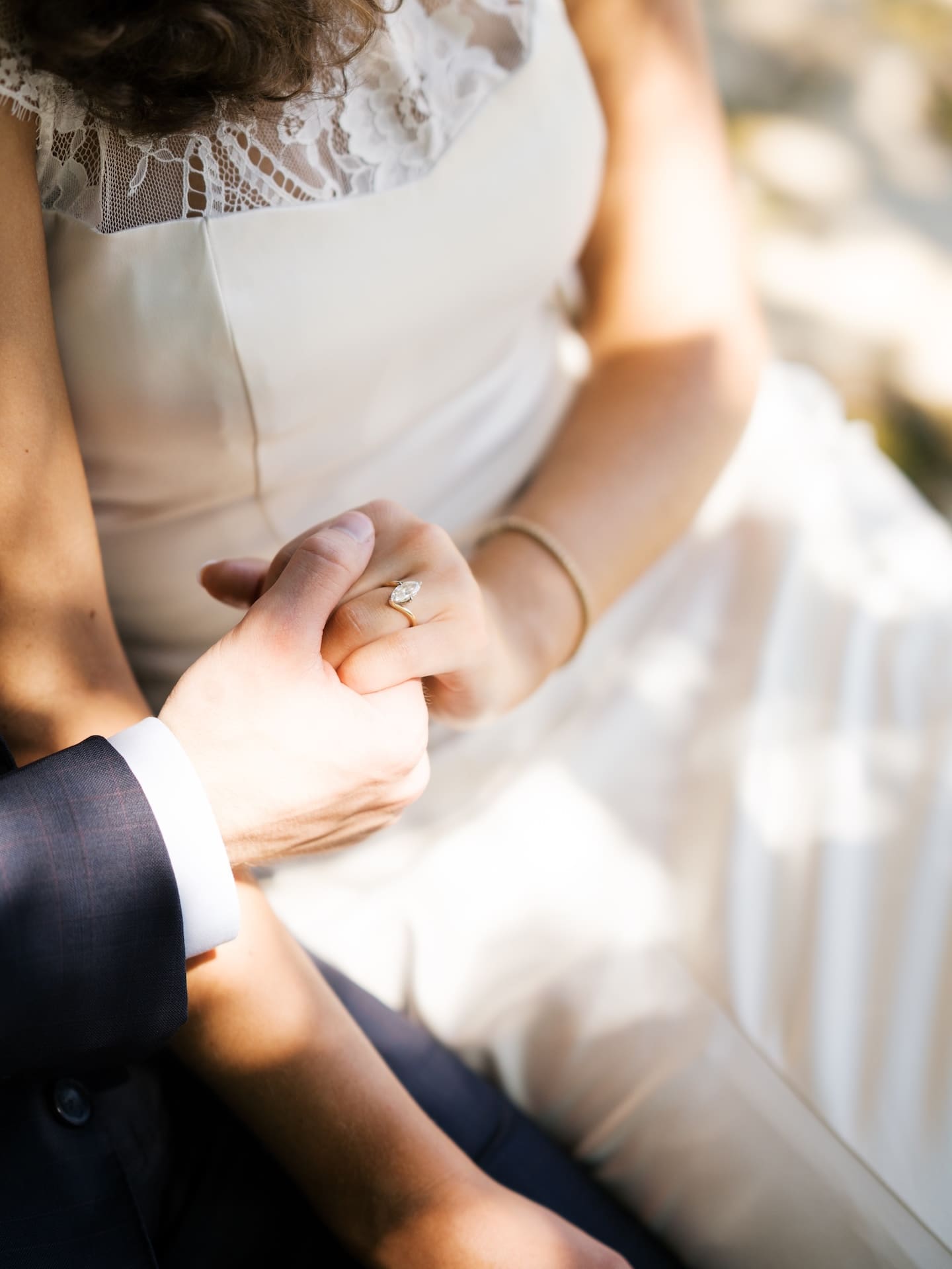 Fall engagement photos of a couple holding hands closely, highlighting a sparkling engagement ring.