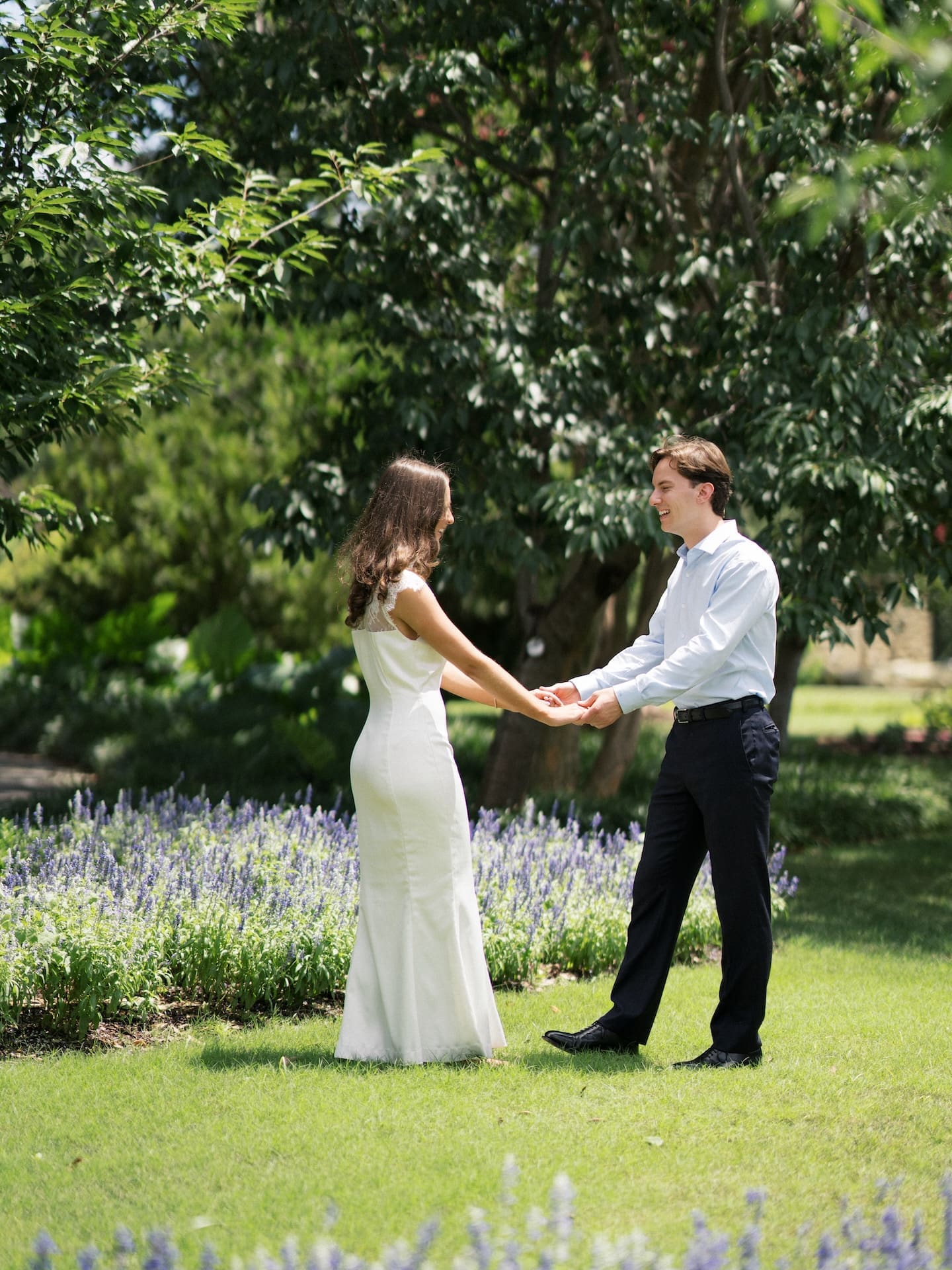 Fall engagement photos of a couple holding hands and laughing beside a bed of purple lavender.