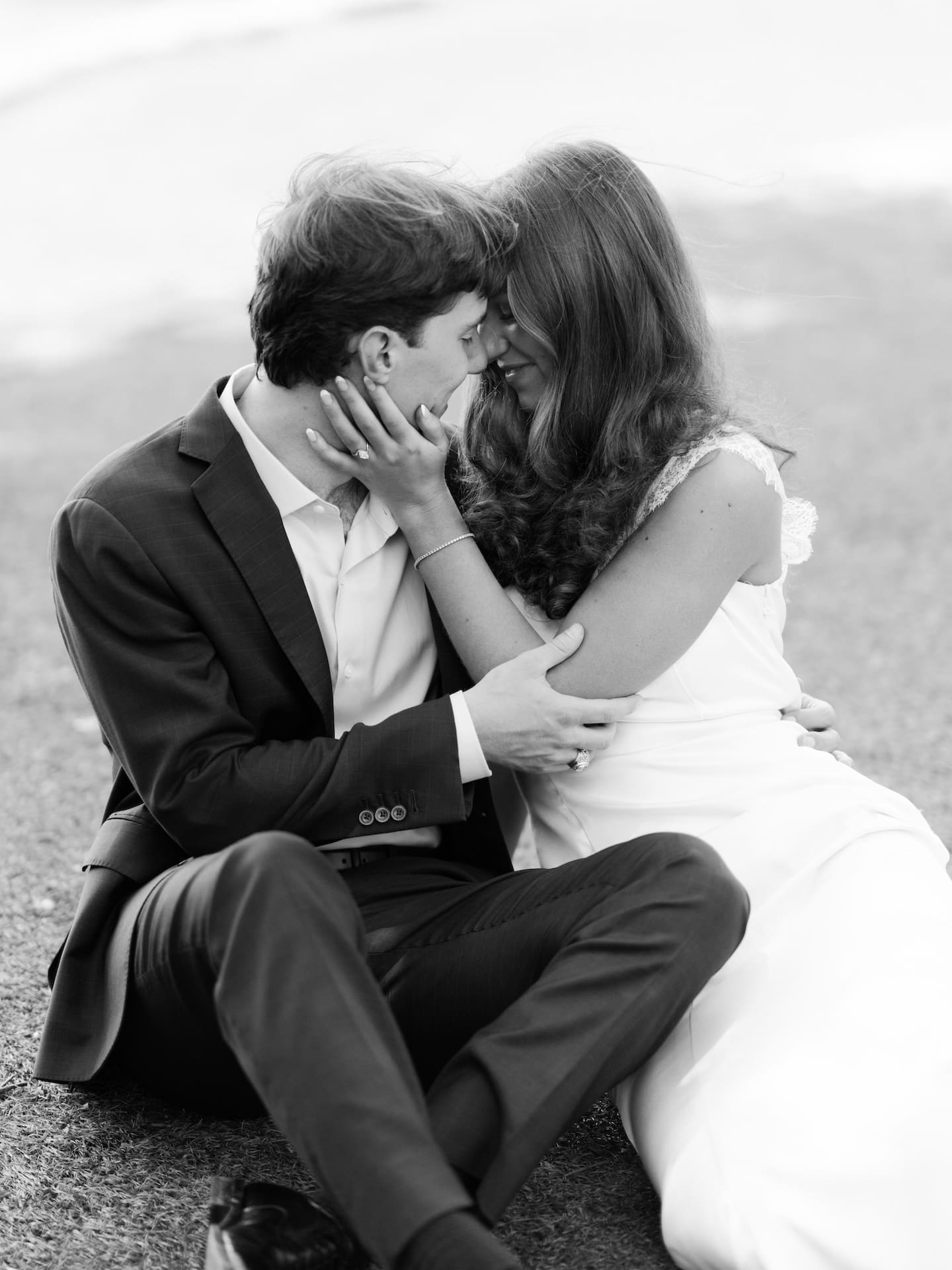 Black and white portrait of a couple sharing an intimate, nose-to-nose embrace.