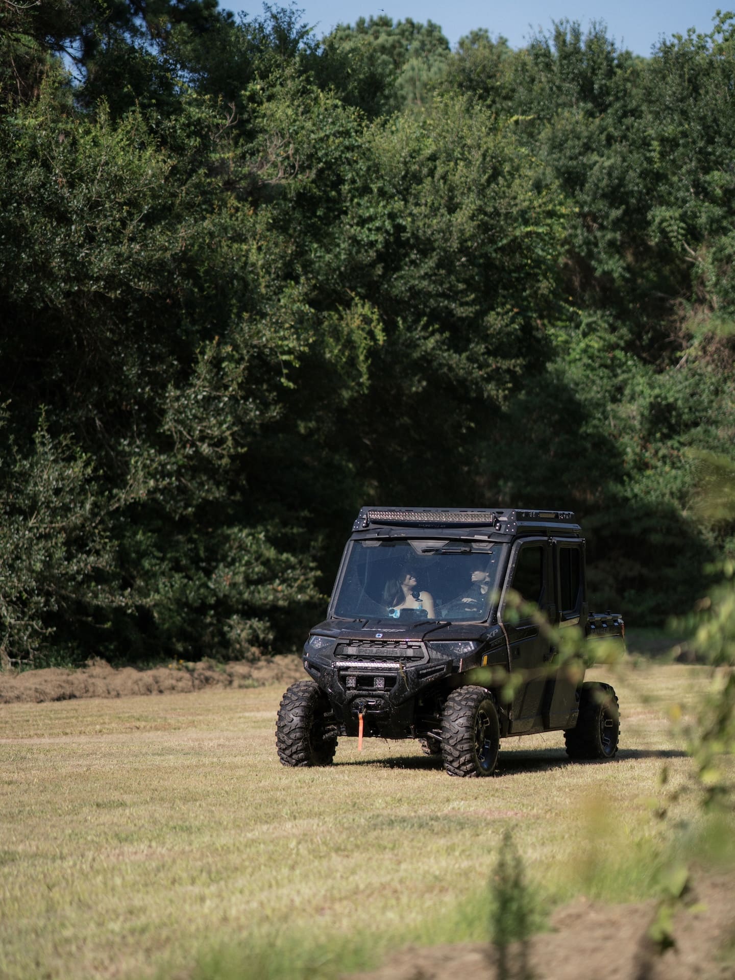Surprise Engagement Proposal Ideas featuring a couple riding an off-road vehicle across a grassy field.