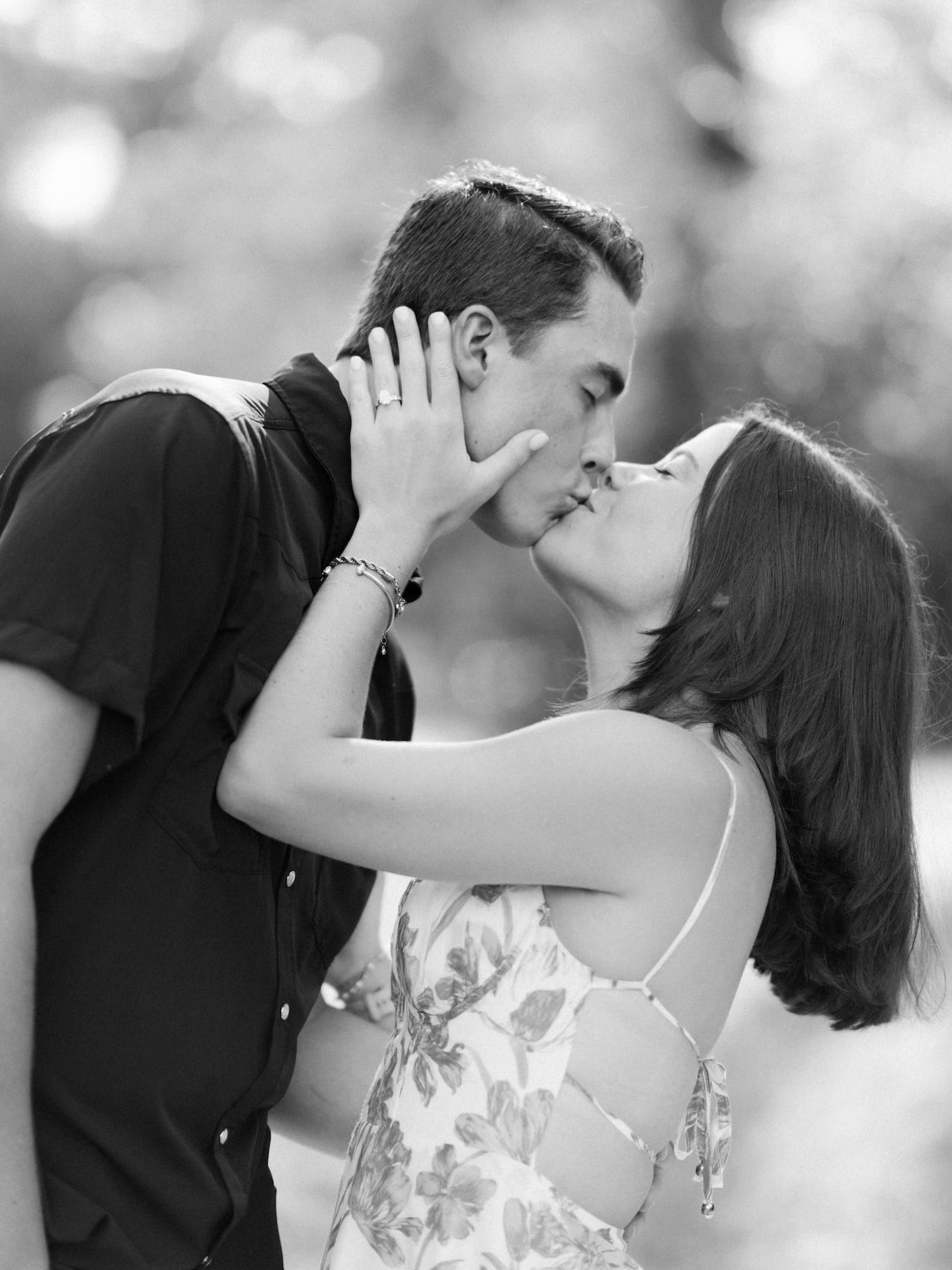 Surprise Engagement Proposal Ideas captured in black and white as a couple shares a joyful kiss.
