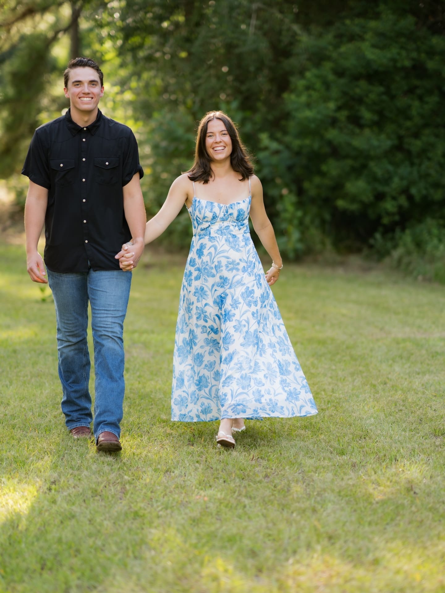 Surprise Engagement Proposal Ideas featuring a couple walking hand in hand across a grassy lawn.