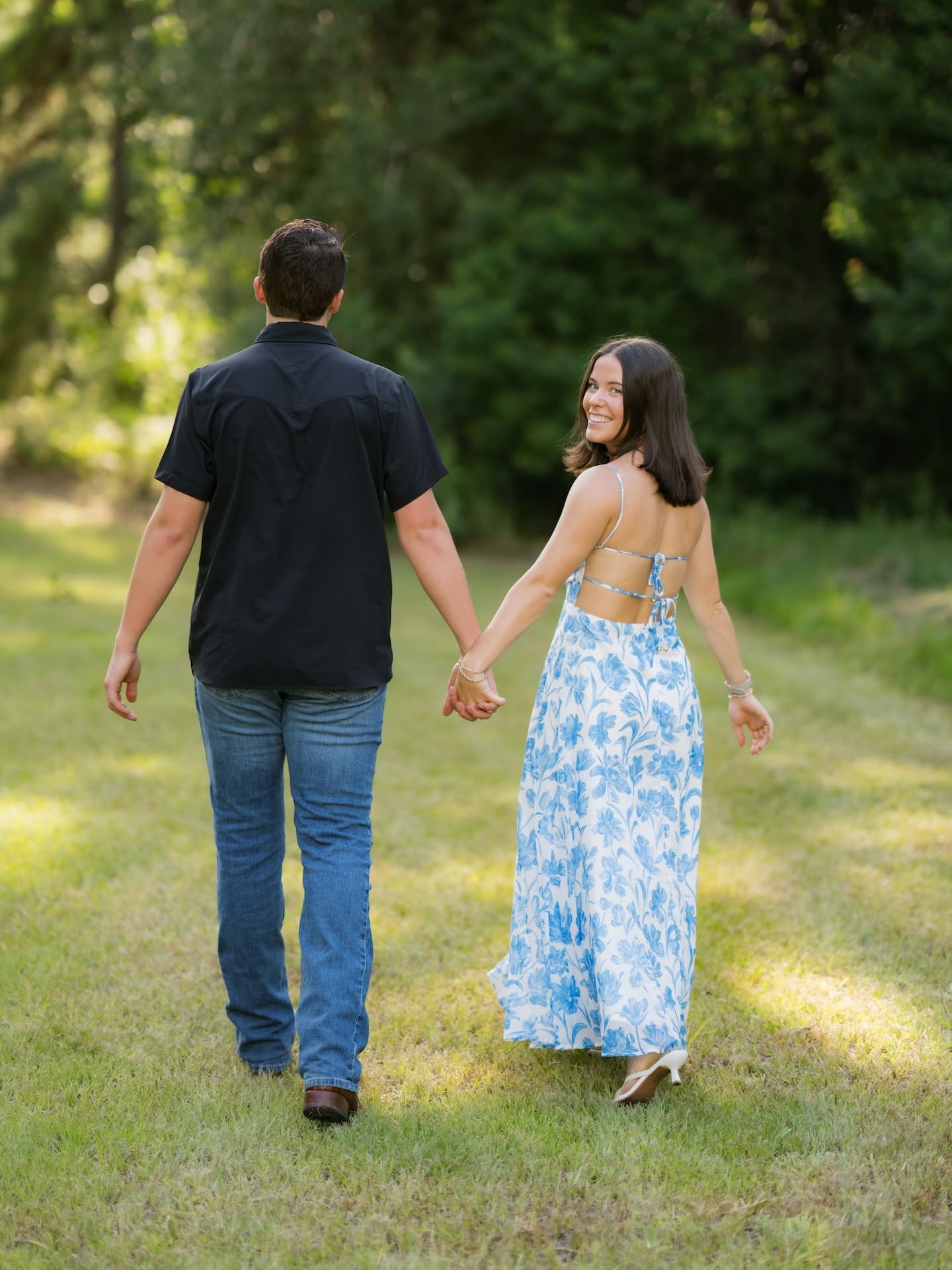 Surprise Engagement Proposal Ideas featuring a couple walking hand in hand, her smiling back at the camera.