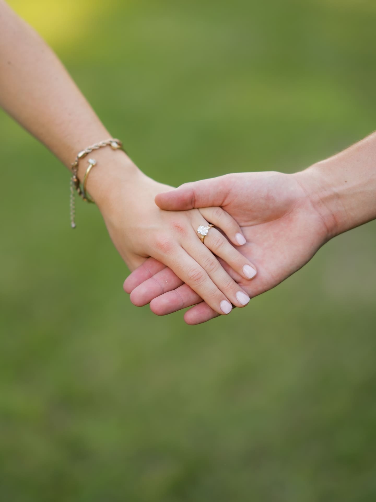 Surprise Engagement Proposal Ideas featuring a close-up of hands showing off a new engagement ring.