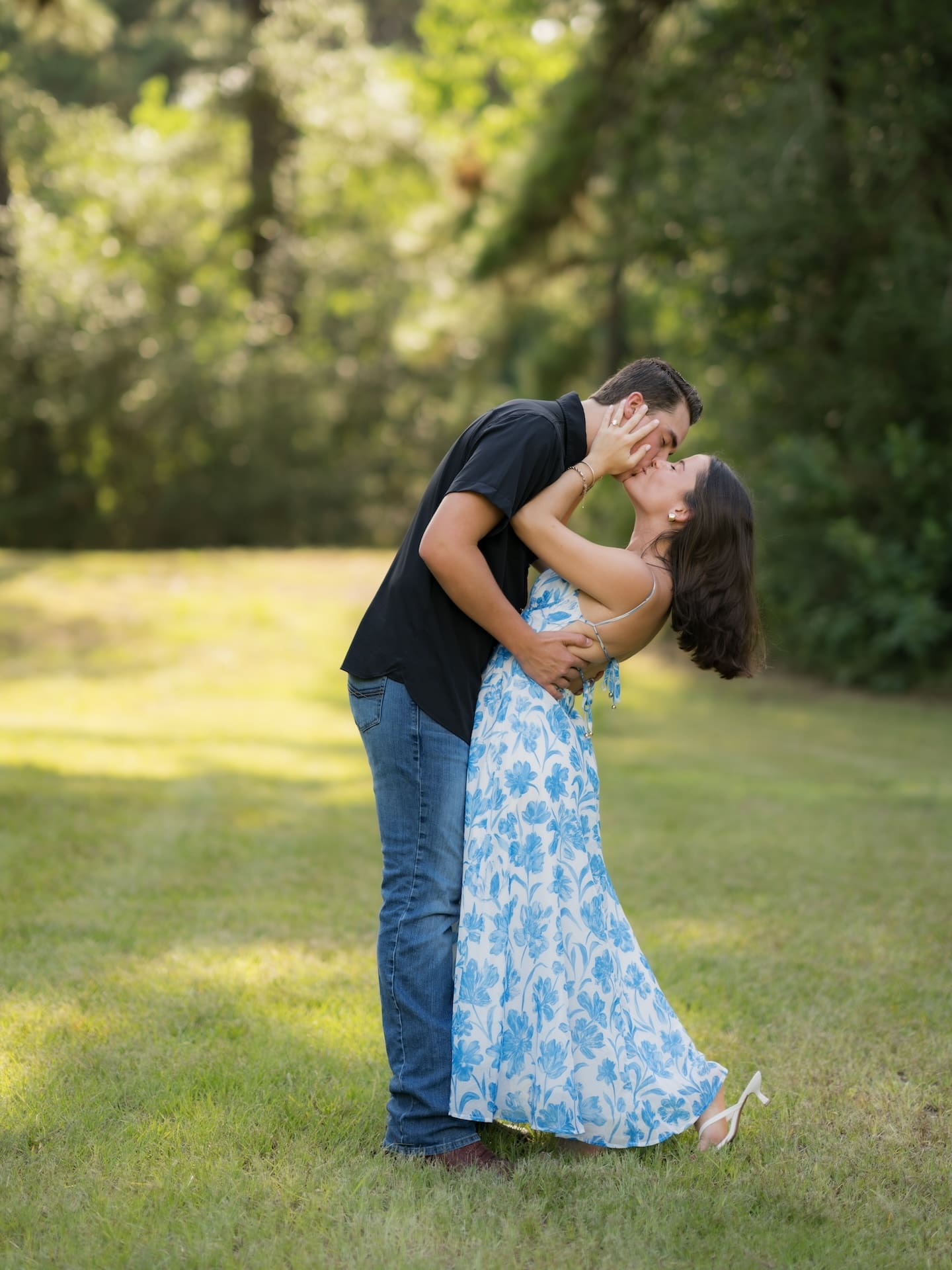 Surprise Engagement Proposal Ideas showing a man dipping his fiancée for a kiss in a grassy field.