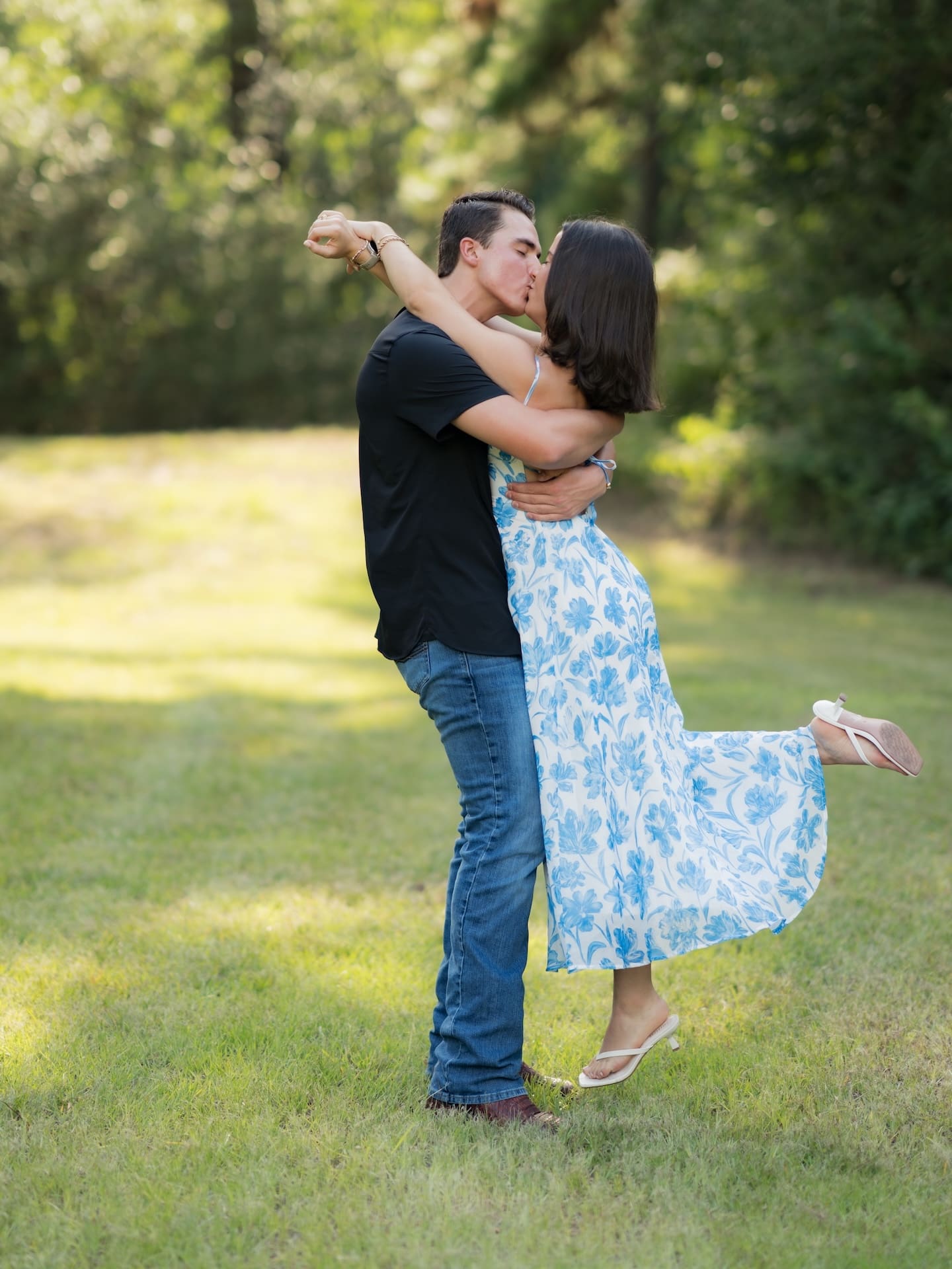 Surprise Engagement Proposal Ideas showing a man dipping his fiancée for a kiss in a sunny field.