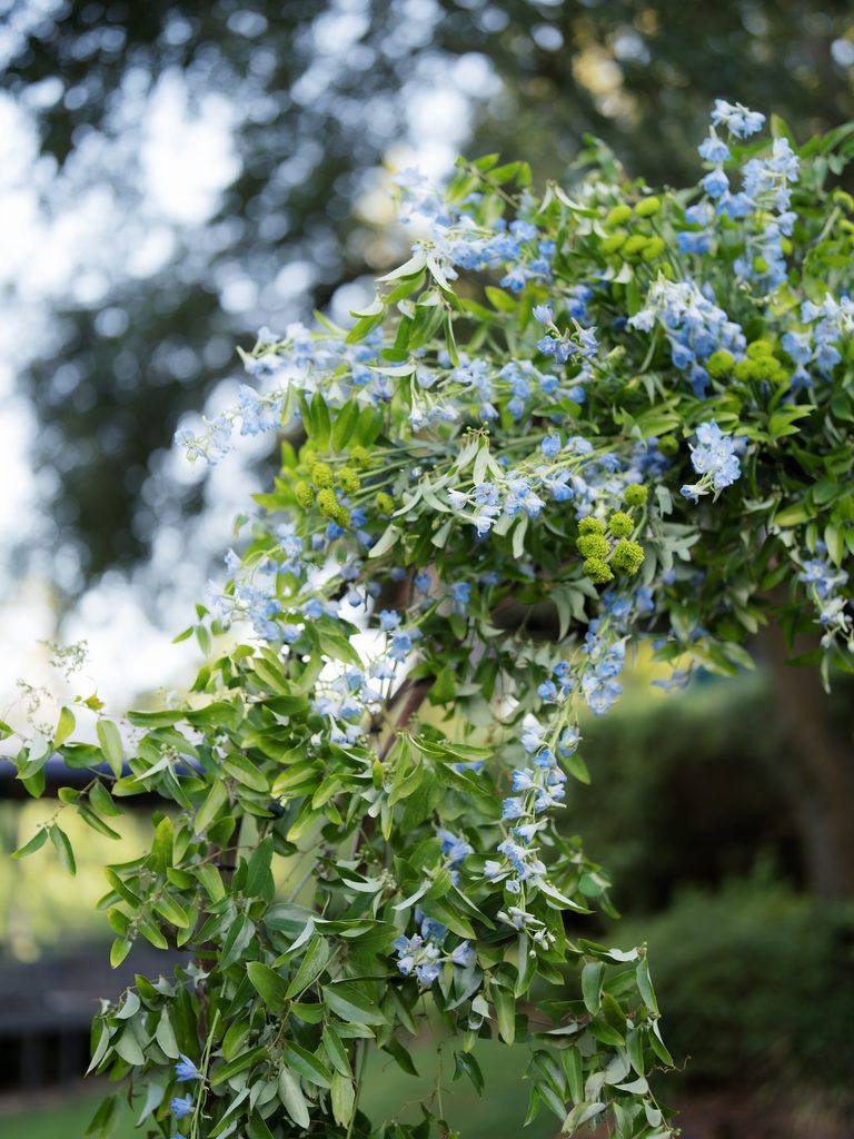 Close-up of soft blue delphinium and greenery on a floral arch used for a garden proposal at Brenners on the Bayou